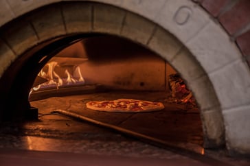 cooking a Pizza in a brick oven
